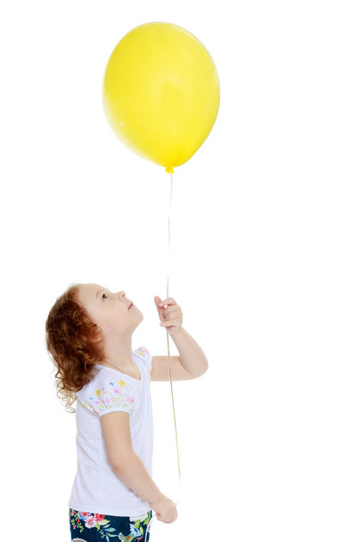 Little girl is playing with a balloon - Foto, immagini