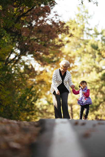 Großmutter und Enkelin auf dem Weg in den Park - Foto, Bild