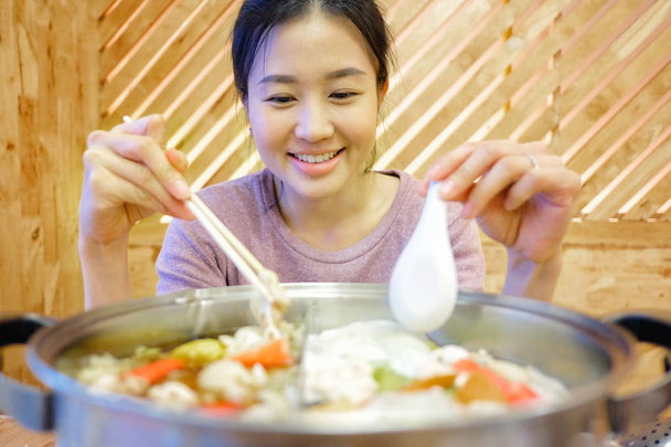 молода жінка насолоджуватися їжею сябу-сябу японський гарячий горщик - Фото, зображення