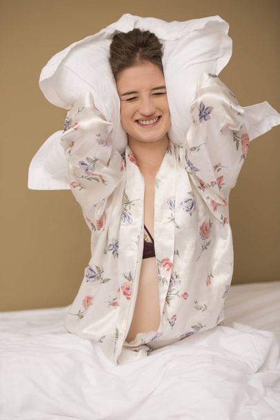 Pelea de almohadas con una mujer feliz y sonriente
 - Foto, Imagen