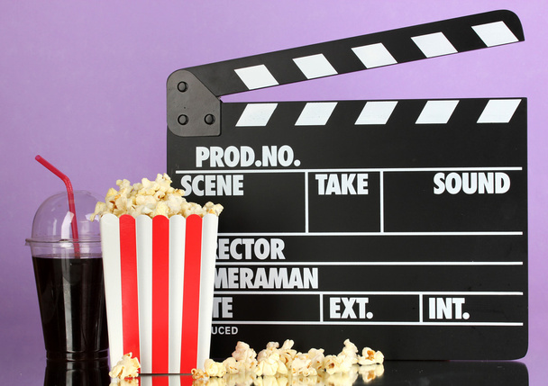 Movie clapperboard, cola and popcorn on purple background - Fotoğraf, Görsel