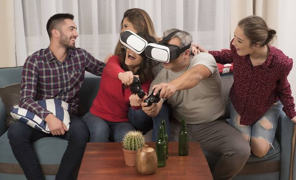 ystävät pelaavat videopelejä yllään virtuaalitodellisuus lasit
 - Valokuva, kuva