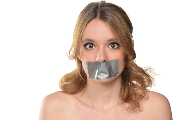 Nuori nainen teipattuna suuhunsa. eristetty valkoisella
 - Valokuva, kuva