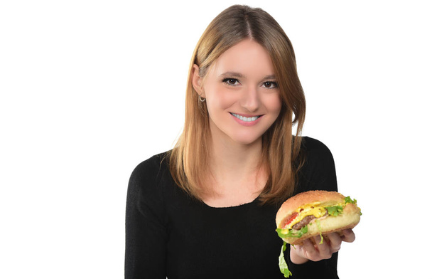 portrait of a beautiful young girl holding a hamburger on the white background - Photo, Image