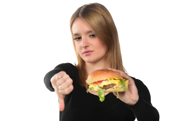Porträt eines schönen jungen Mädchens mit einem Hamburger auf weißem Hintergrund - Foto, Bild