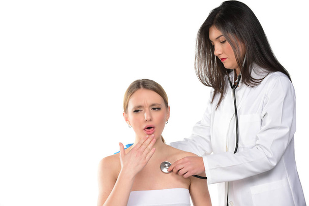 Médecin féminin vérifiant jeune femme avec stéthoscope. isolé
 - Photo, image