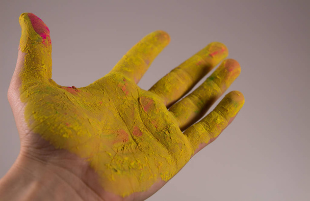 Рука брудна в жовтій фарбі Холі
 - Фото, зображення