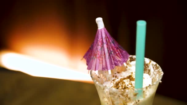 Koktejl jahodový krém a pití slámou. Bílé koktejl ve skle s deštníkem zblízka - Záběry, video