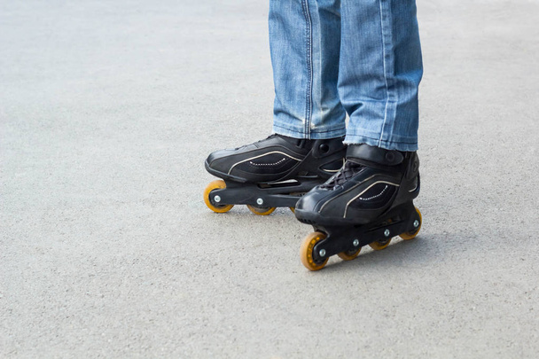 Young man in blue jeans riding roller skates in the city. Close up legs - Φωτογραφία, εικόνα