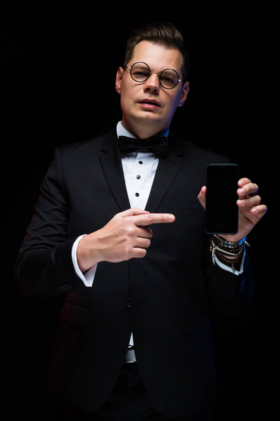 junger schöner Mann im Anzug mit modernem Smartphone  - Foto, Bild