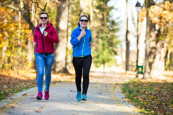 Two women running in city park - Foto, immagini