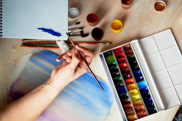 The process of creating an illustration by the artist. Watercolor paint.Hand with brush - Fotoğraf, Görsel