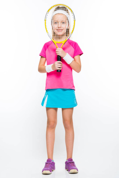 Schattig klein meisje kijkend door tennisracket  - Foto, afbeelding