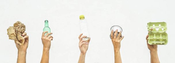 Lidské ruce držící objekty recyklovatelné jako papír, sklo, plast, hliník na bílém pozadí - Eco Pojem recyklace - zaměřit se na ruce - Fotografie, Obrázek