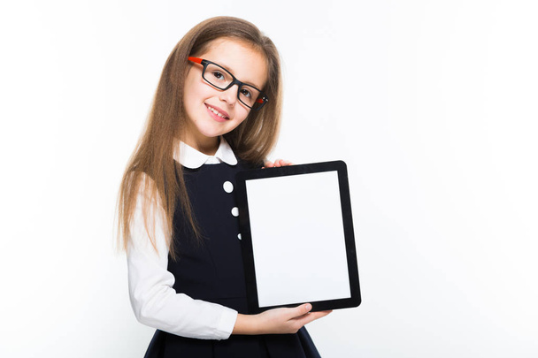 Cute little girl holding digital tablet isolated on white background  - Foto, Imagen