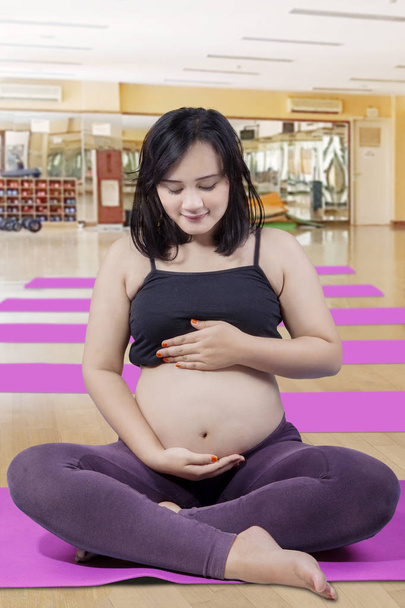 Expecting mother after morning exercise with hands on her stomach - Foto, Imagem