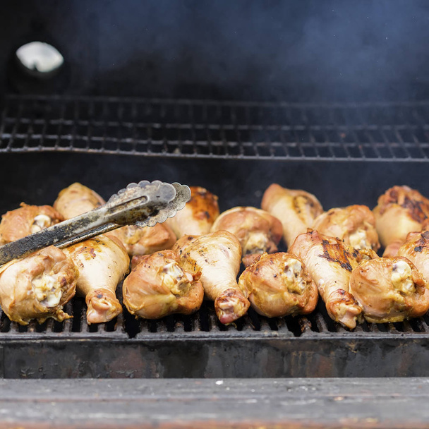 Appetizing turkey drumsticks on the grill, on charcoal stove with fire and smoke close-up . Concept summer picnic, nutrition, diet - Photo, image
