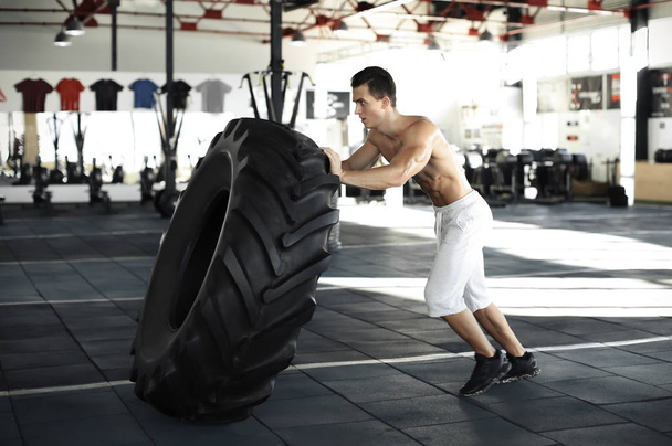 Young man flipping heavy tire - Photo, image