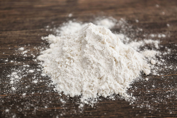 Heap of white wheat flour on wooden table - Photo, image