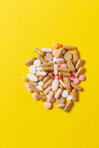 Лекарства белые красочные круглые таблетки расположены абстрактно на желтом фоне цвета. Аспирин, капсульные таблетки для дизайна. Здоровье, лечение, выбор концепции здорового образа жизни. Копирование космической рекламы
. - Фото, изображение