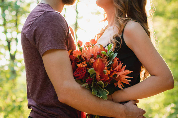 man met meisje verlovingsring handen bloemen - Foto, afbeelding