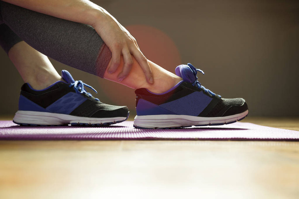 Young woman suffering from an ankle injury while exercising. Spo - Foto, Imagem