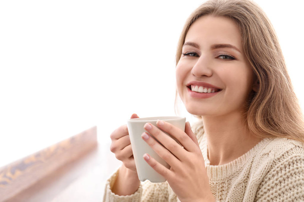 Smiling young woman with drink indoors - Foto, Imagen
