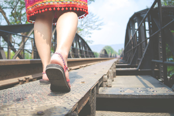 закрытие ботинок во время прогулки в солнечный день по железнодорожному мосту
 - Фото, изображение