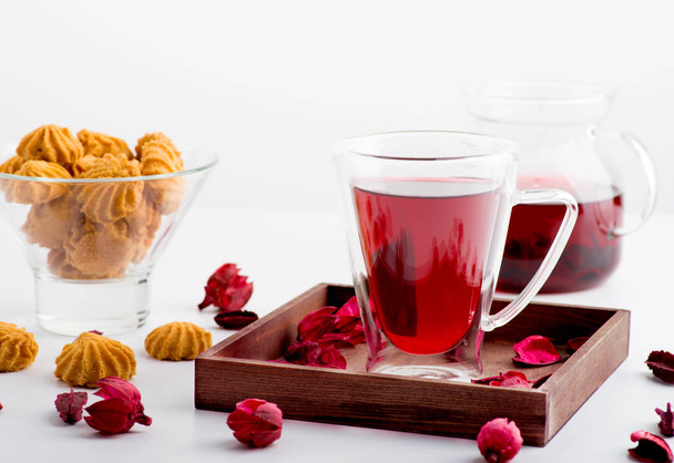 A csésze a hibiszkusz tea dupla üveg az asztalon.  - Fotó, kép