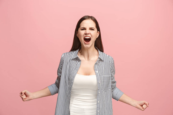 Nuori emotionaalinen vihainen nainen huutaa vaaleanpunainen studio tausta
 - Valokuva, kuva