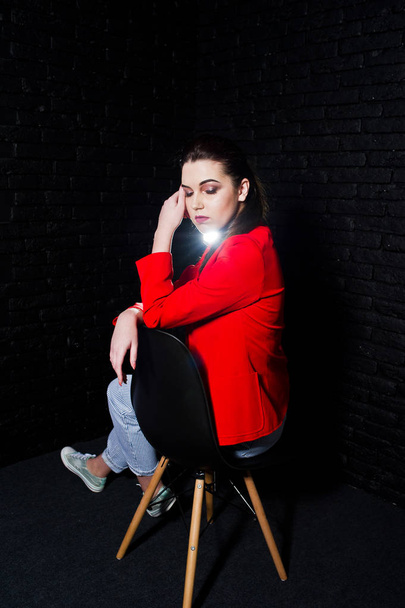 Stylish brunette girl on red jacket against studio black brick w - Foto, immagini