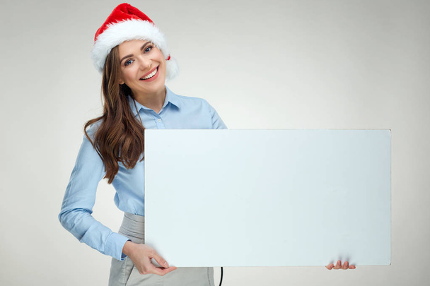 Businesswoman wearing blue shirt and santa hat holding white sign board  - Фото, зображення