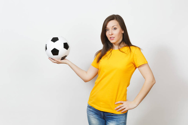 Beautiful European young cheerful happy woman, football fan or player in yellow uniform holding soccer ball isolated on white background. Sport, play football, health, healthy lifestyle concept. - Fotó, kép