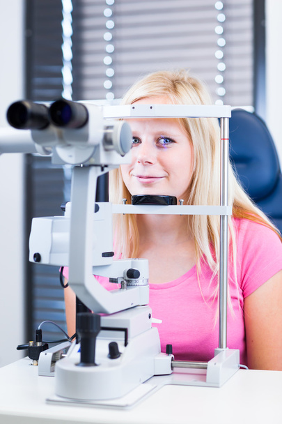 Concepto de optometría: paciente joven y bonita que se examina los ojos
 - Foto, imagen
