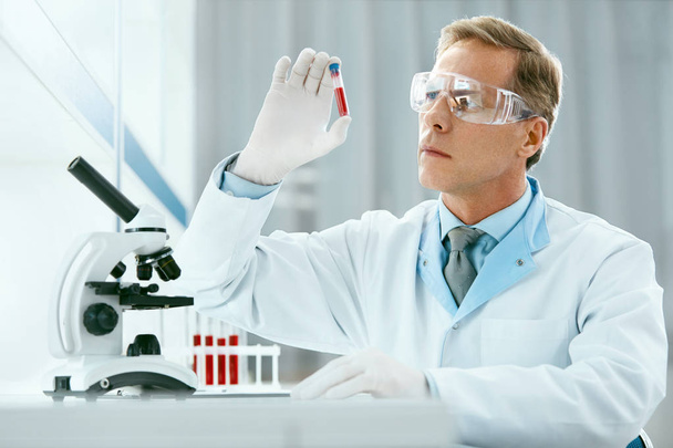 Laboratóriumi teszt férfi orvos elemezni, vérmintát - Fotó, kép