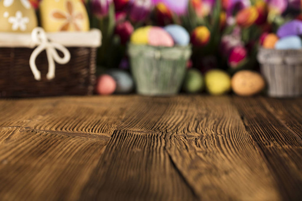 Easter theme. Easter eggs. Colorful tulips. Rustic wooden table. Shallow depth of focus. Bokeh background.  - Фото, изображение