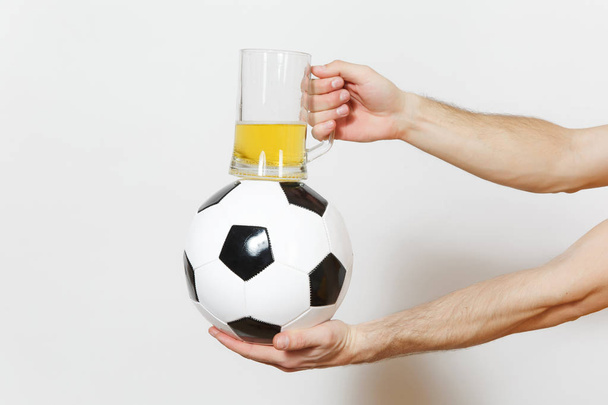 男性の手は水平サッカー クラシック ホワイト黒ボール、白い背景で隔離のビールのパイント マグカップを保持しています。スポーツ、サッカー、健康、健康的なライフ スタイル コンセプトを再生. - 写真・画像