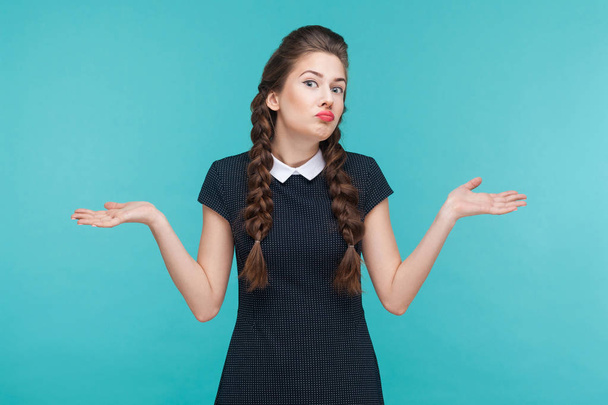 confused businesswoman in black dress with divorced hands looking at camera on blue background - Foto, Imagem