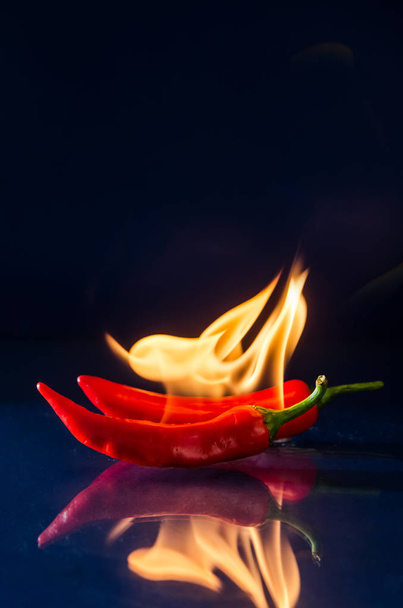 Piros forró chili paprika fekete háttér láng - Fotó, kép