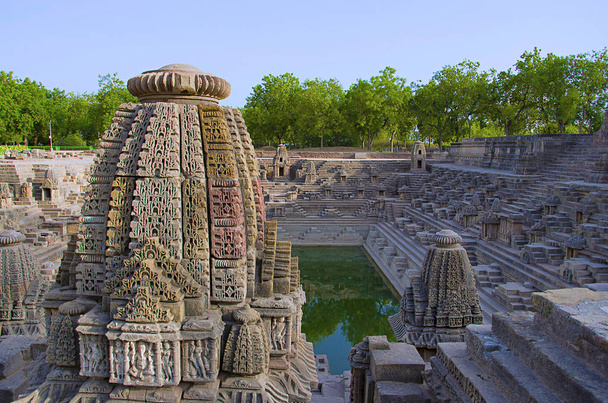 Pequeños santuarios y escalones para llegar al fondo del embalse, del Templo del Sol. Modhera pueblo del distrito de Mehsana, Gujarat
 - Foto, Imagen