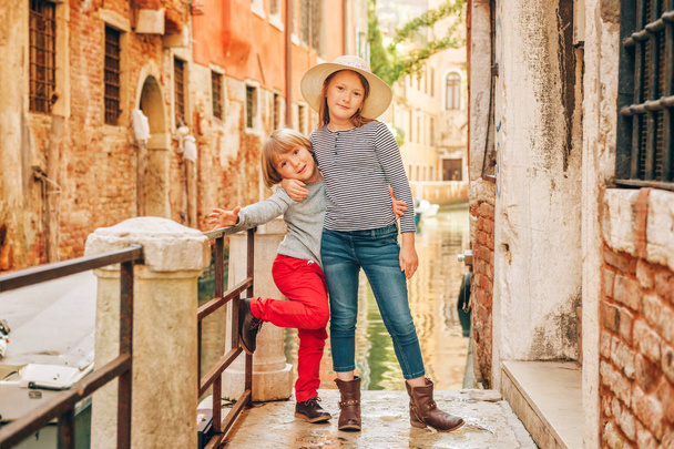 Two kids playing on the bridge in Venice. Little girl and boy visiting Venice, Italy. Small tourists in Europe - Foto, Imagen
