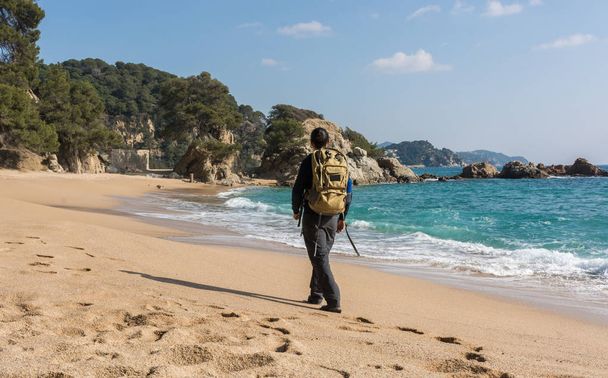 man walking among the rocks near a beach paradise  - Фото, изображение