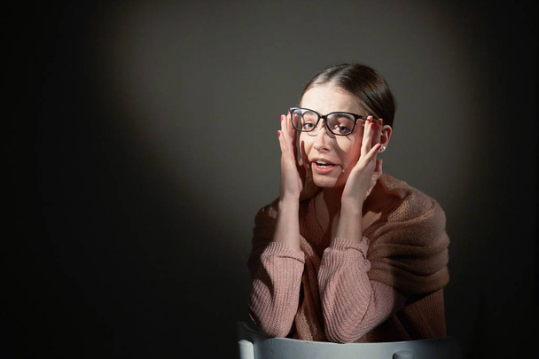 girl in glasses in studio on a dark background. light spots. - Photo, Image