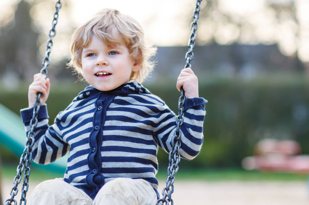 Portret van peuter jongen hebben plezier op buiten speeltuin - Foto, afbeelding