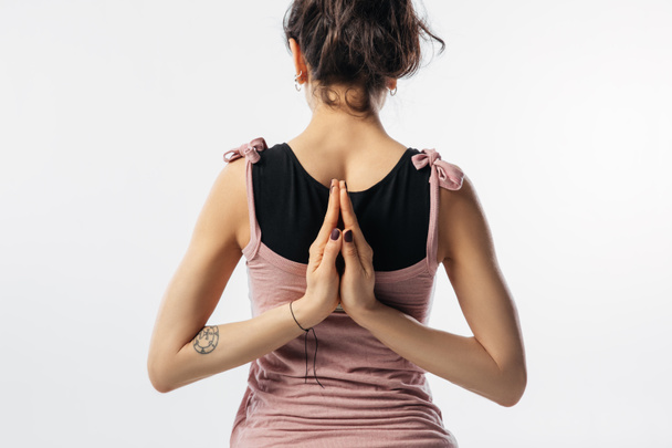 vista trasera de la mujer practicando yoga con namaste detrás de la espalda aislado en blanco
 - Foto, Imagen