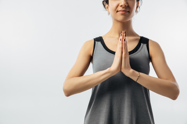 обрезанный образ женщины, практикующей йогу руками в намасте
 - Фото, изображение