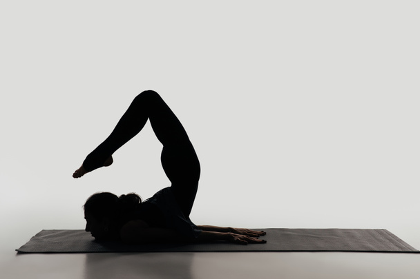 vue latérale de la femme pratiquant le yoga sur blanc
 - Photo, image