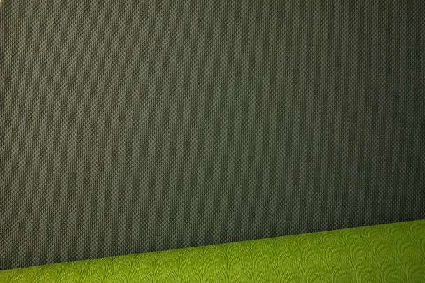 top view of green rolled yoga mat - Fotó, kép
