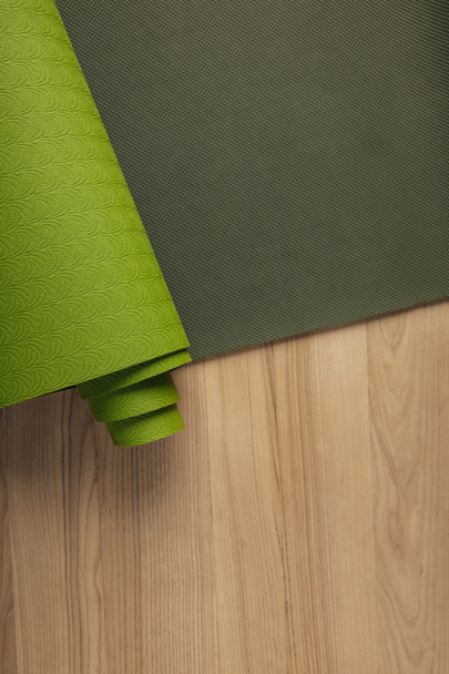 top view of green yoga mat on wooden brown floor - Photo, Image