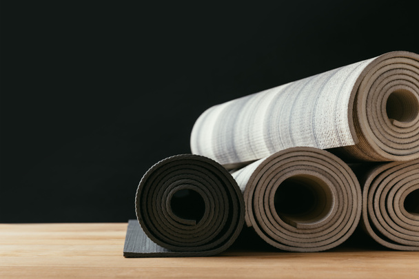 diferentes tapetes de ioga laminados em mesa de madeira
 - Foto, Imagem